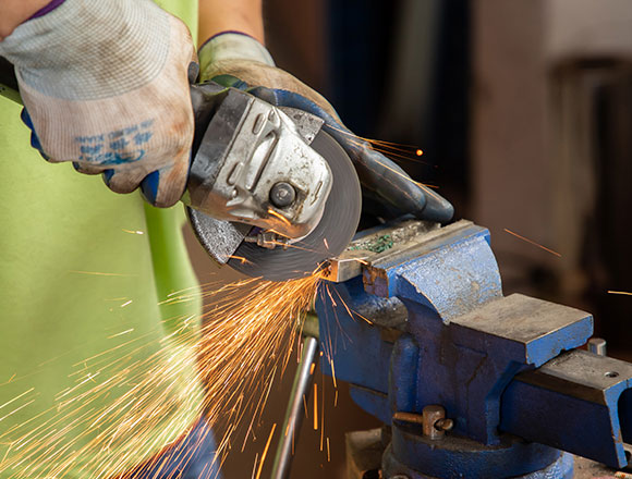 A worker is grinding parts