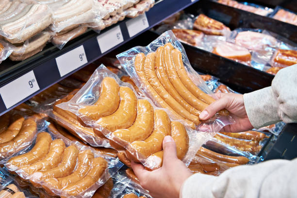 Salchichas en manos de un comprador en un supermercado