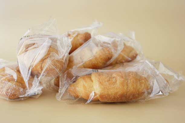 プラスチックに包まれた新鮮なクロワッサンの詰め合わせが、簡単に取り出せるようにきちんと積み重ねられています